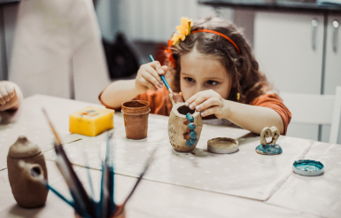 young girl decorating cup