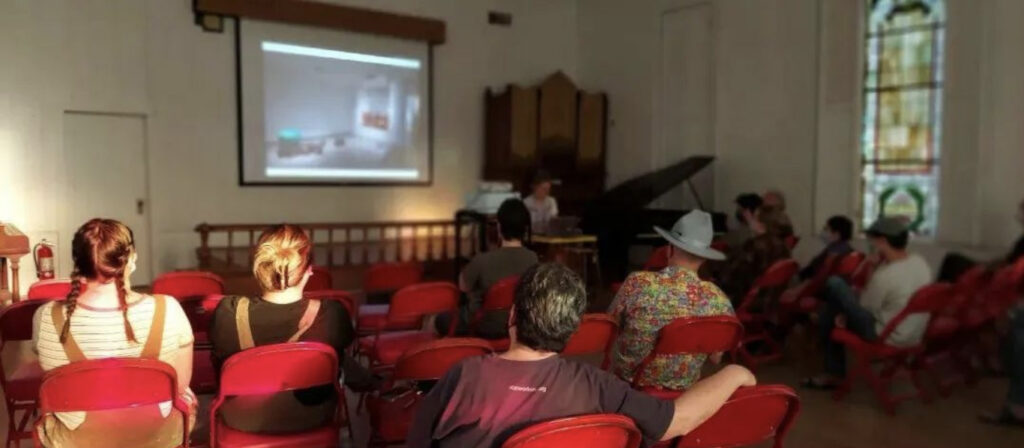 people sitting in auditorium watching a presentation