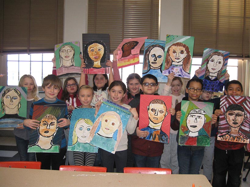Group of children holding self portraits