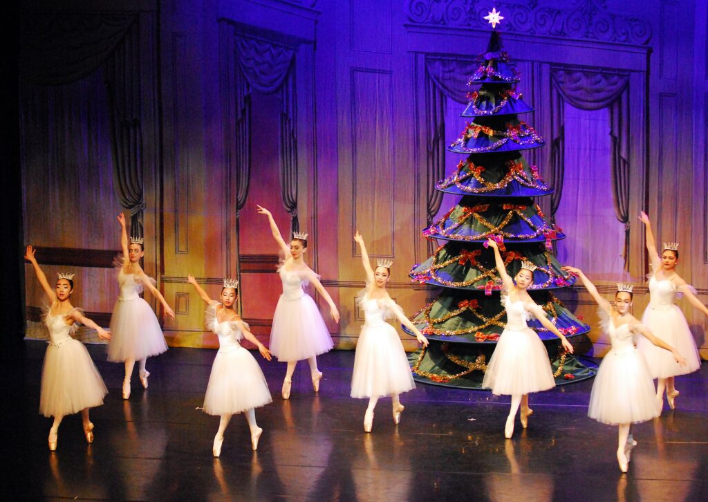 dancers in front of christmas tree