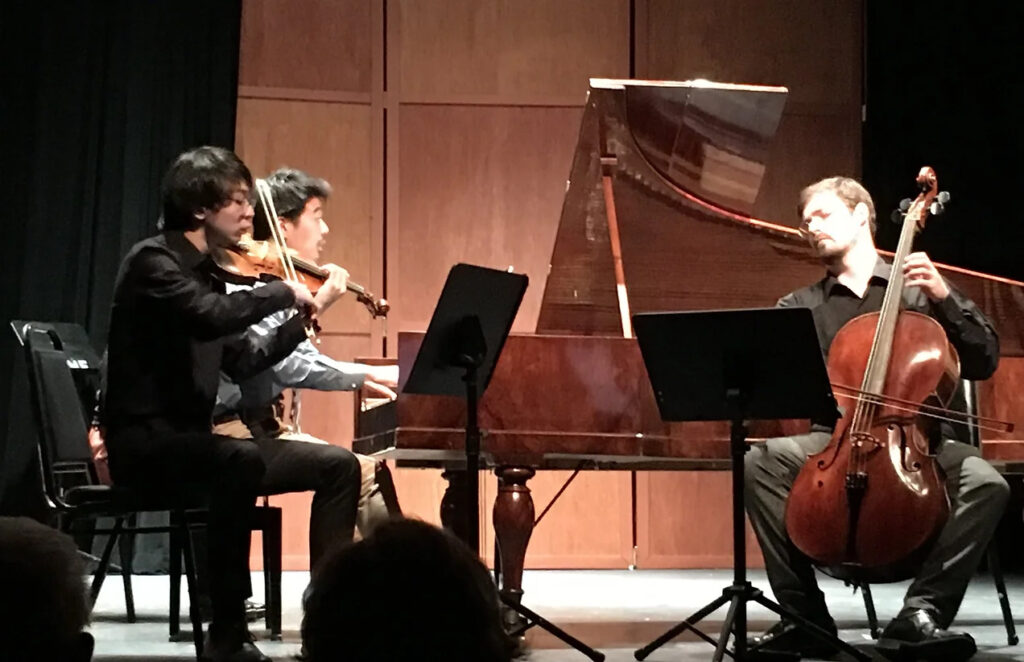 Three students performing on stage