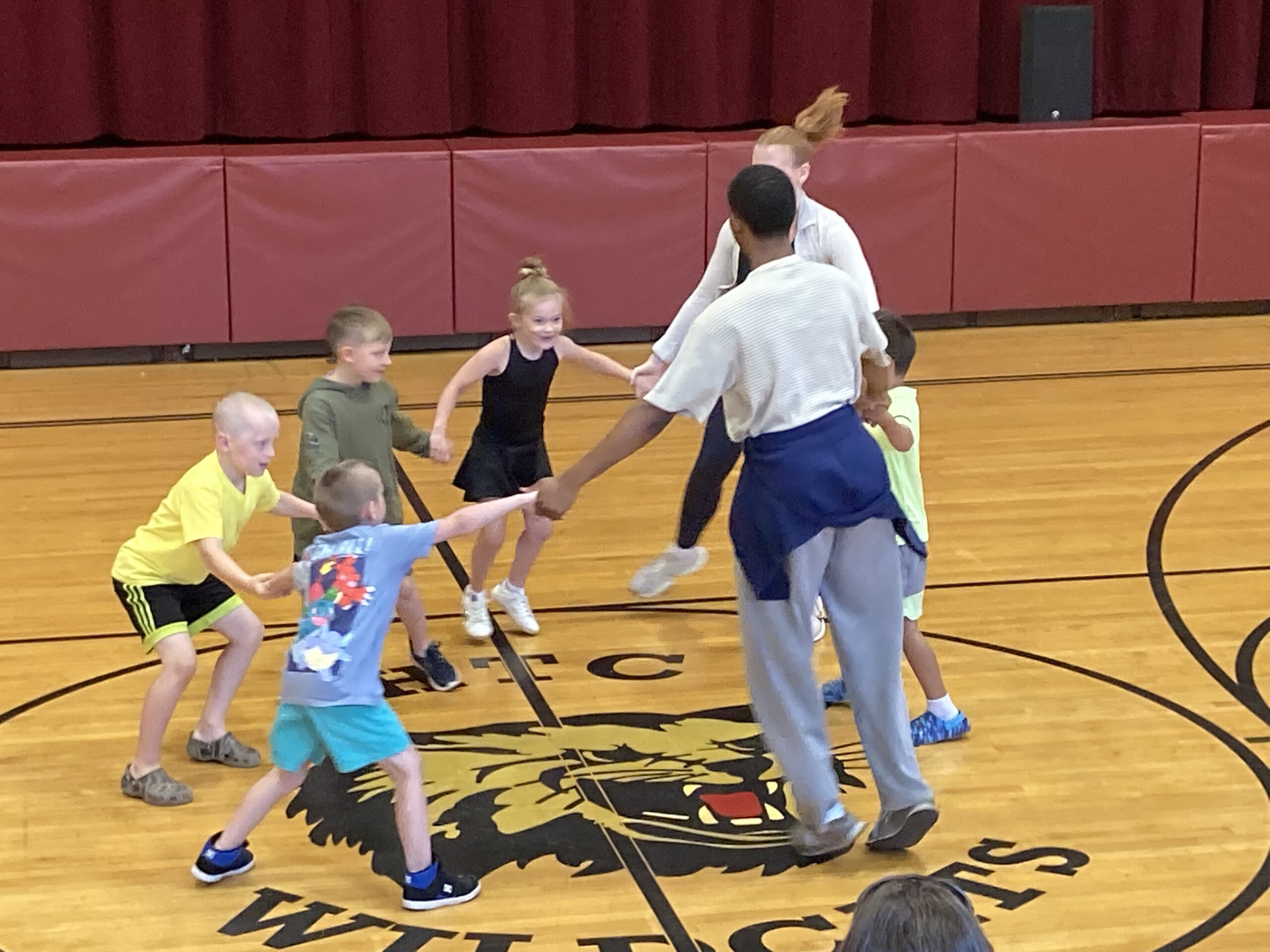 A group of kids dance in a circle