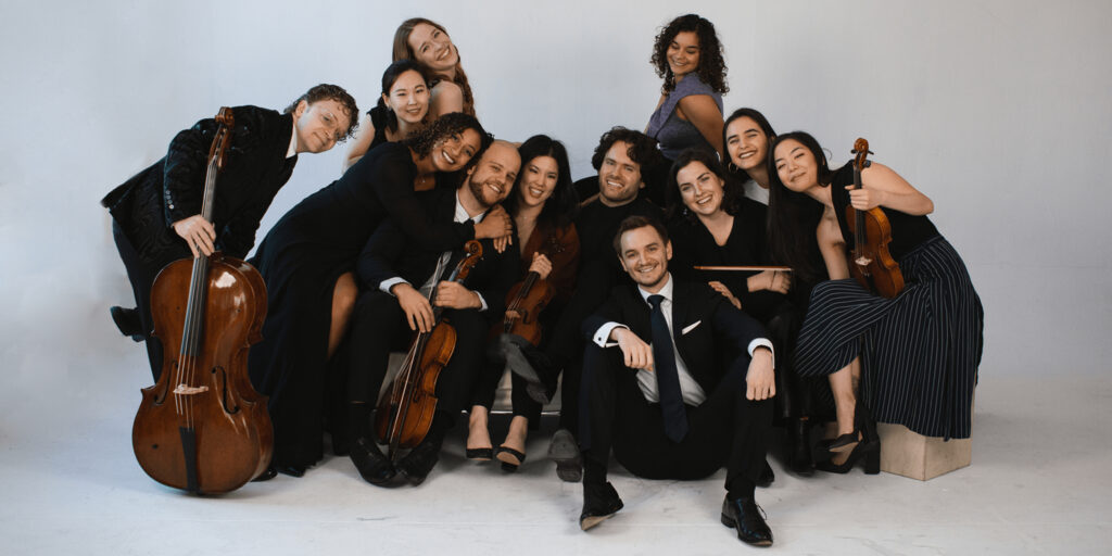 Group of musicians pose against a white background