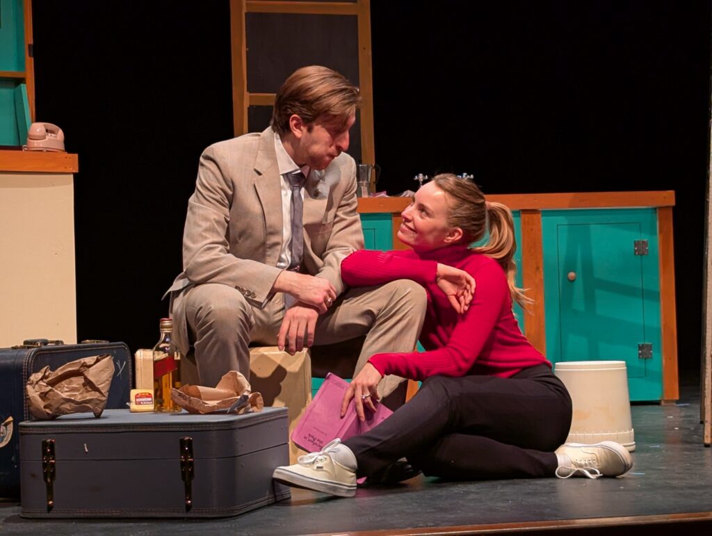 Man and woman sit together on a stage