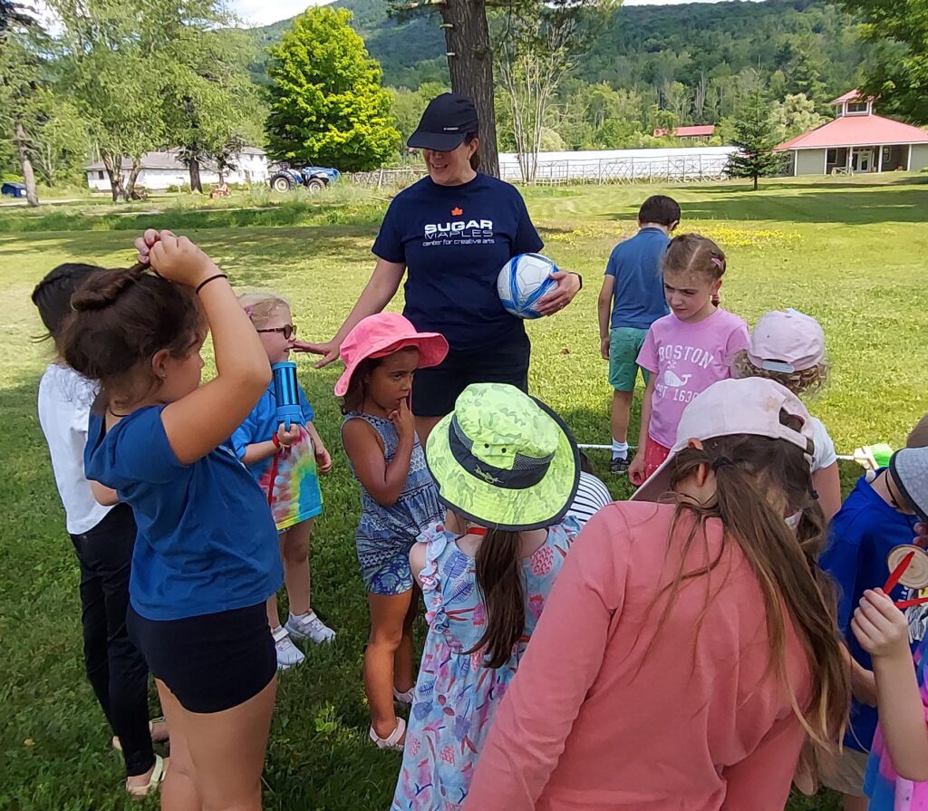Young children gather outside in the summer