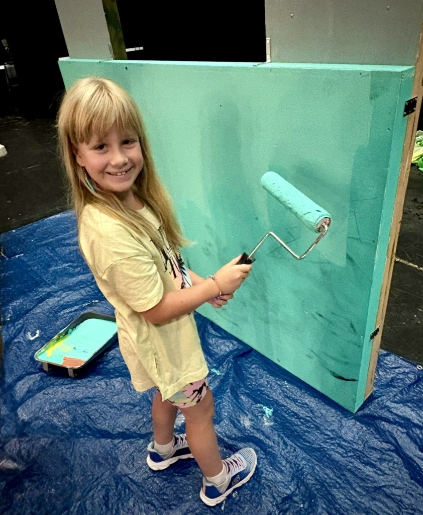 Smiling child painting a set