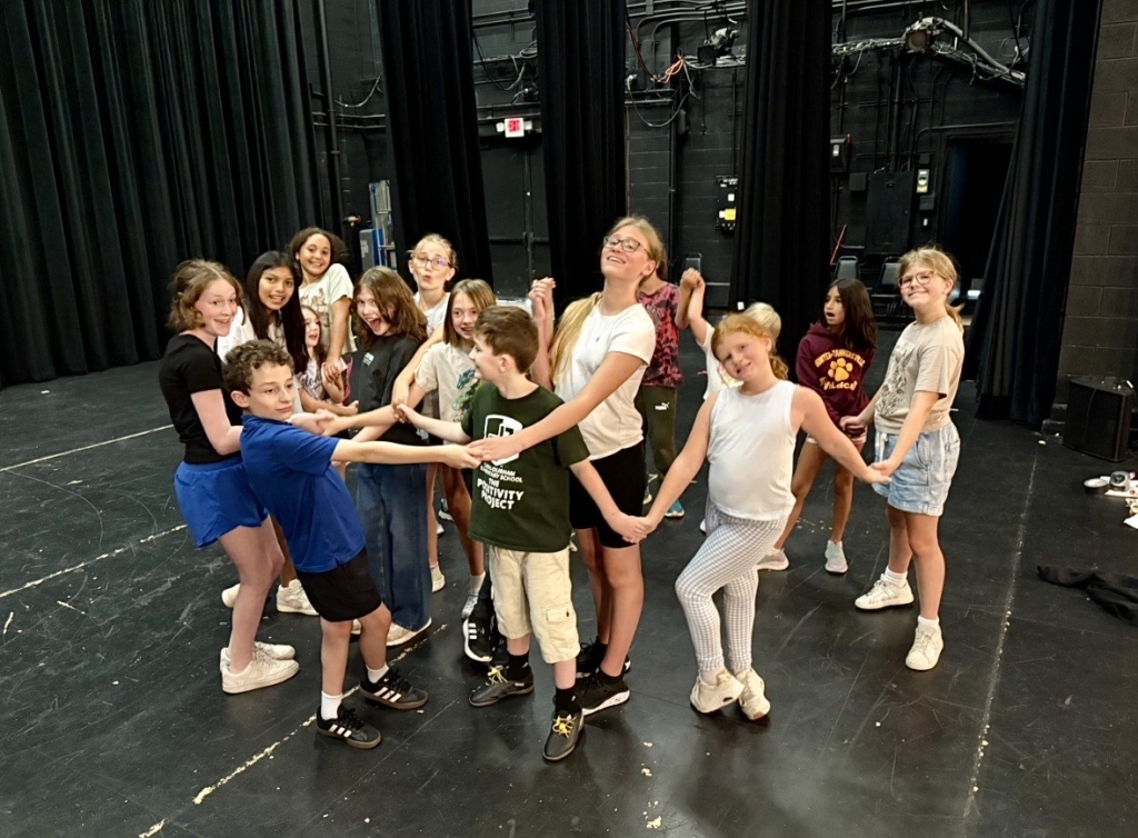 Group of students in a circle on stage