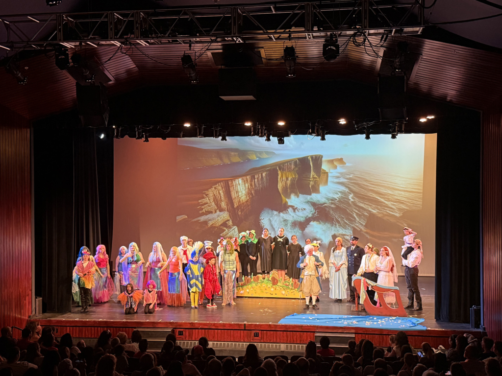 Cast of The Little Mermaid stand on the stage of the Orpheum