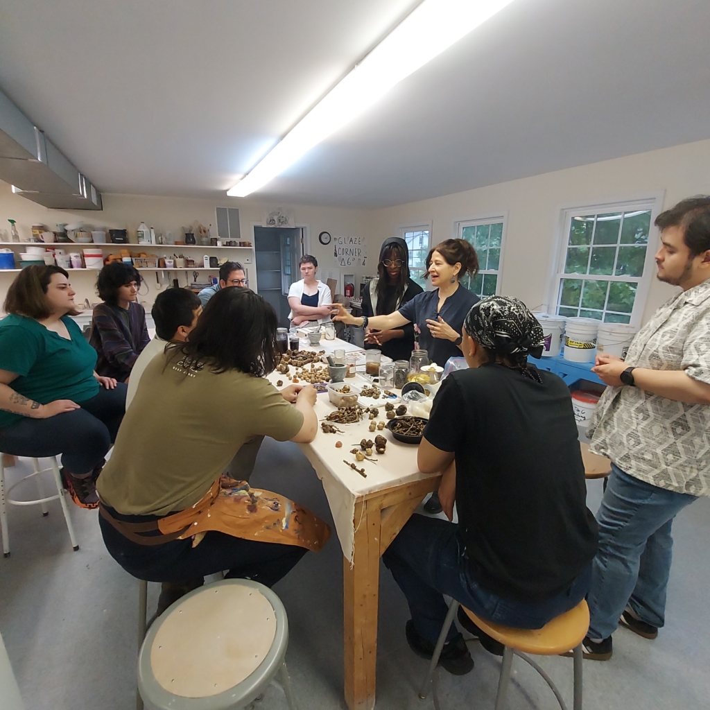 A group of people sit around a table with art objects on the table.